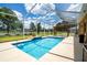 Screened-in pool featuring waterfall, well-manicured landscape, and pergola, perfect for enjoying the outdoors at 5815 Ne 70Th St, Silver Springs, FL 34488