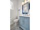 Charming bathroom features a blue vanity, decorative mirror, and unique patterned tile flooring at 6573 S Magnolia Ave, Ocala, FL 34471