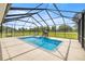 A screened-in pool with an elephant fountain overlooks an expansive lawn and mature trees at 6573 S Magnolia Ave, Ocala, FL 34471