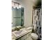 Modern bathroom featuring a vanity with stylish light fixtures and a decorative shower curtain at 6836 Sw 179Th Court Rd, Dunnellon, FL 34432