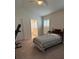 Neutral bedroom with a cozy bed, white shutters, and ensuite bathroom access at 6836 Sw 179Th Court Rd, Dunnellon, FL 34432
