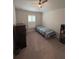 Bedroom with neutral carpet, a bed with quilt bedding, and a window with shutters at 6836 Sw 179Th Court Rd, Dunnellon, FL 34432