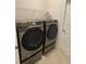 Modern laundry room featuring a front-load washer and dryer set with wire shelving above at 6836 Sw 179Th Court Rd, Dunnellon, FL 34432