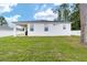 A well maintained backyard with a white stucco home featuring a covered patio at 7479 Sw 130Th Ln, Ocala, FL 34473
