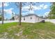 Lush backyard and white exterior featuring multiple windows and partial view of the roofline at 7479 Sw 130Th Ln, Ocala, FL 34473