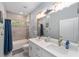 Stylish bathroom boasting double sinks, tiled shower/tub, and nautical decorations at 7479 Sw 130Th Ln, Ocala, FL 34473