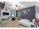 Football-themed bedroom featuring fan, toys, dark accent wall and natural light at 7479 Sw 130Th Ln, Ocala, FL 34473