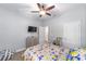 Neutral bedroom features Pokemon bedding, ceiling fan, natural light, and multiple closets at 7479 Sw 130Th Ln, Ocala, FL 34473