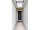 A covered entryway features a gray front door and neutral walls at 7479 Sw 130Th Ln, Ocala, FL 34473
