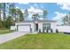 Exterior view of a white single-story home with attached garage on landscaped lawn at 7479 Sw 130Th Ln, Ocala, FL 34473