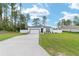 Exterior view of a white single-story home with attached garage on landscaped lawn at 7479 Sw 130Th Ln, Ocala, FL 34473
