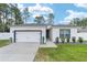 Charming single-story home boasts a manicured lawn, attached garage and modern exterior details at 7479 Sw 130Th Ln, Ocala, FL 34473