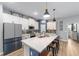 Modern kitchen with an island that has barstool seating, pendant lights, and white cabinetry at 7479 Sw 130Th Ln, Ocala, FL 34473