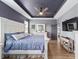 A primary bedroom featuring tray ceilings, hardwood floors, an ensuite bath, and a neutral color palette at 7479 Sw 130Th Ln, Ocala, FL 34473