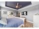A primary bedroom featuring tray ceilings, hardwood floors, and a neutral color palette at 7479 Sw 130Th Ln, Ocala, FL 34473