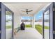 Covered patio with ceiling fan, open blue double doors, and grill at 7479 Sw 130Th Ln, Ocala, FL 34473