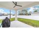 Covered patio featuring ceiling fan, view of white fence, and grill at 7479 Sw 130Th Ln, Ocala, FL 34473