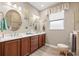Well-lit bathroom with double vanity, framed mirrors, updated fixtures, and decorative floral accents at 7917 Sw 85Th Loop, Ocala, FL 34476