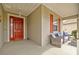 Charming front porch with red front door, red shutters, and cozy seating area with blue cushions at 7917 Sw 85Th Loop, Ocala, FL 34476