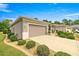 Home's exterior featuring a long driveway leading to an attached two-car garage and manicured landscaping at 7917 Sw 85Th Loop, Ocala, FL 34476