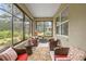 Relaxing sunroom with wicker seating and scenic views of the lush, landscaped backyard at 7917 Sw 85Th Loop, Ocala, FL 34476