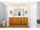 Bright bathroom features double sinks, wood cabinets, and a large mirror at 8303 Sw 82Nd Cir, Ocala, FL 34481