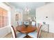 Light dining room features a round wood table, four upholstered chairs, and stylish overhead lighting at 8303 Sw 82Nd Cir, Ocala, FL 34481