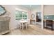Dining room features white table with seating for four, natural light, and wood-look flooring at 8303 Sw 82Nd Cir, Ocala, FL 34481