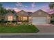 Elegant home exterior at twilight with manicured lawn, warm lighting, and a welcoming two-car garage at 8303 Sw 82Nd Cir, Ocala, FL 34481
