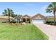 Charming single-story home featuring a well-manicured lawn, beautiful landscaping, and a brick-paved driveway at 8303 Sw 82Nd Cir, Ocala, FL 34481