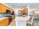 Open kitchen features bright wood cabinets, stainless appliances, and quartz countertops with barstool seating at 8303 Sw 82Nd Cir, Ocala, FL 34481