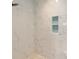 This shower showcases marble-look tiling, a niche, and a showerhead at 8303 Sw 82Nd Cir, Ocala, FL 34481