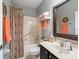 Well-lit bathroom with a decorative mirror and colorful shower curtain at 8447 Sw 82Nd Loop, Ocala, FL 34481