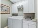 Functional laundry room with modern appliances and custom white cabinetry at 8447 Sw 82Nd Loop, Ocala, FL 34481