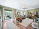 Spacious living room featuring wood floors, neutral tones, and screened-in porch access at 8447 Sw 82Nd Loop, Ocala, FL 34481