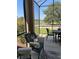 A screened-in patio with comfortable seating and a table features views of the lush landscaping at 8447 Sw 82Nd Loop, Ocala, FL 34481