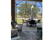 A covered patio features an outdoor dining table and comfortable seating with views of the golf course at 8447 Sw 82Nd Loop, Ocala, FL 34481