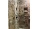 Modern shower with stone walls, glass door, and built-in shelving at 8447 Sw 82Nd Loop, Ocala, FL 34481