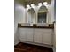 Bright bathroom featuring double sinks, wood counter, white cabinets, and decorative mirrors at 8770 Sw 196Th Terrace Rd, Dunnellon, FL 34432