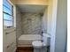 Bright bathroom with tiled shower, tub, window, and low consumption toilet at 8770 Sw 196Th Terrace Rd, Dunnellon, FL 34432