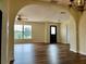 Bright, open-concept living room with wood flooring, chandelier and view to backyard at 8770 Sw 196Th Terrace Rd, Dunnellon, FL 34432