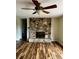 Cozy living room with sleek floors, stone fireplace, and ceiling fan offers a relaxing atmosphere at 8770 Sw 196Th Terrace Rd, Dunnellon, FL 34432
