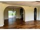 Bright, open-concept living room with wood flooring, chandelier and view to backyard at 8770 Sw 196Th Terrace Rd, Dunnellon, FL 34432