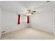 Cozy bedroom features neutral carpet, a ceiling fan, and a window with curtains at 8885 Sw 90Th Ave, Ocala, FL 34481