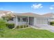 Charming single-story home featuring a covered porch, well-manicured lawn, and attached garage at 8885 Sw 90Th Ave, Ocala, FL 34481