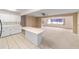 Open-concept living and kitchen area with white cabinets and a large window at 8885 Sw 90Th Ave, Ocala, FL 34481