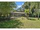 Private backyard featuring a screened-in pool, lush landscaping, and mature trees at 9175 Se 7Th Avenue Rd, Ocala, FL 34480