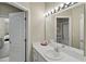 Well-lit bathroom vanity featuring a large mirror and access to an adjacent bathroom at 9175 Se 7Th Avenue Rd, Ocala, FL 34480