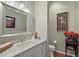 Well-lit powder room with marble countertop, decorative mirror, and stylish fixtures at 9175 Se 7Th Avenue Rd, Ocala, FL 34480