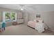 Comfortable bedroom with a large window and a dresser, accented by a ceiling fan at 9175 Se 7Th Avenue Rd, Ocala, FL 34480